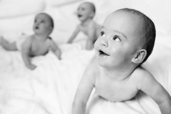 Three babies on a bed.