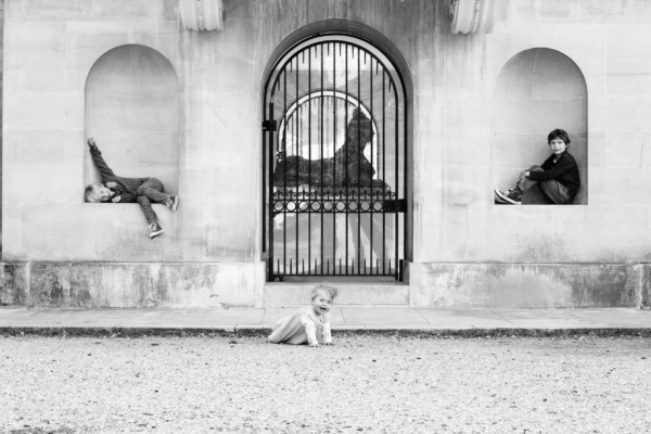 Portrait of siblings against London architectural wall.