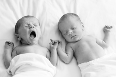 Twin newborns first photoshoot, with one of them yawning.