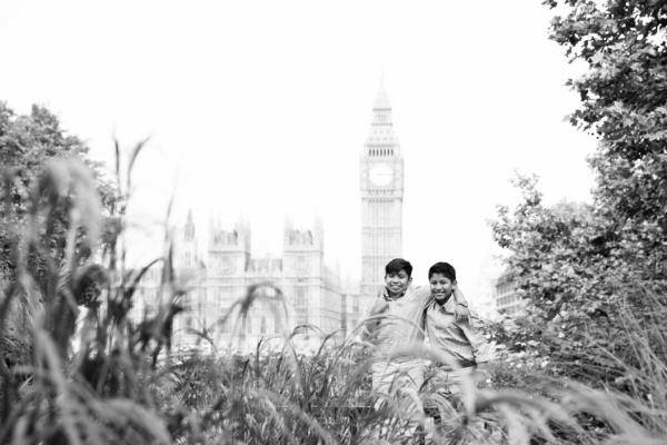 Brothers hug in gardens with Big Ben and the Houses of Parliament in the background.