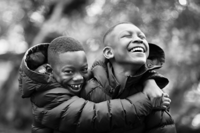 Two teenage brothers hug each other.