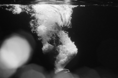 A child jumps into water, creating a splash.