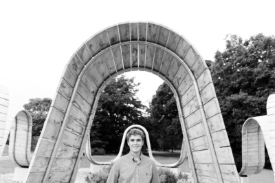 Teenager portrait framed by wooden sculpture.