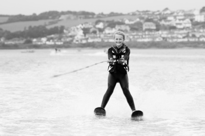 A teenager waterskis across the sea.