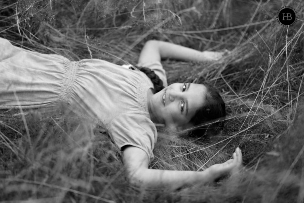 girl-lies-in-grass-looking-at-camera