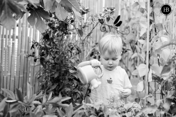 little-boy-waters-plants-on-balcony