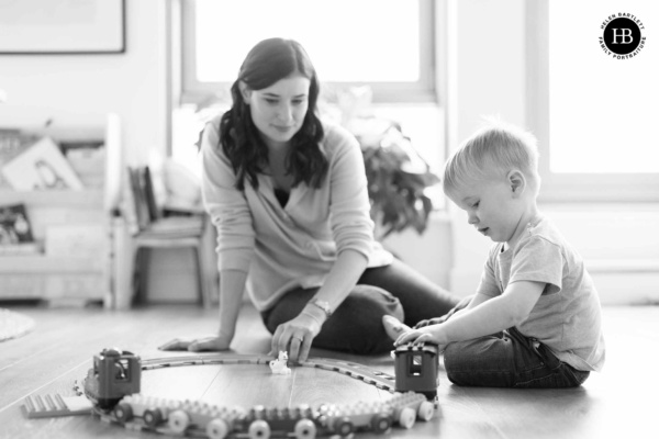 mother-and-son-play-with-toy-train-on-family-photo-shoot