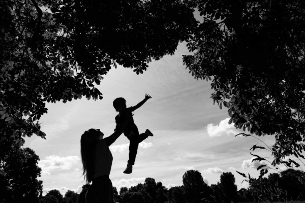 mother-lifts-son-in-air-silhouette