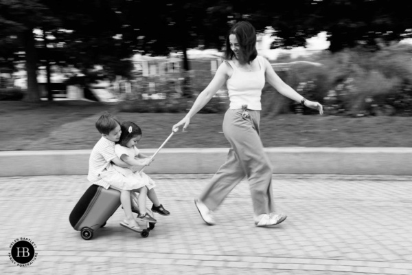 fun-family-photo-children-on-suitcase-pulled-by-mum