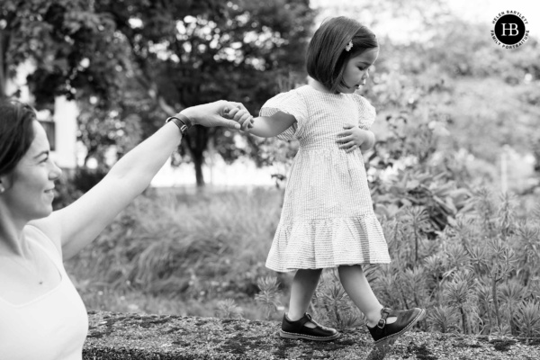 mother-helps-daughter-balance-on-wall