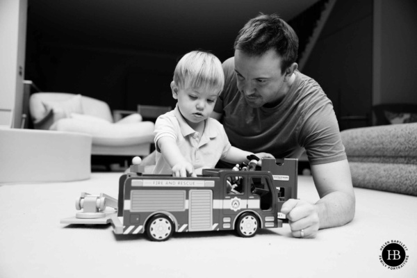 father-and-son-play-with-bus-on-family-photo-shoot