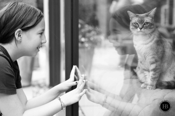 girl-looks-at-cat-through-window