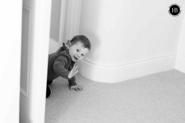 little-girl-waves-while-crawling-through-door