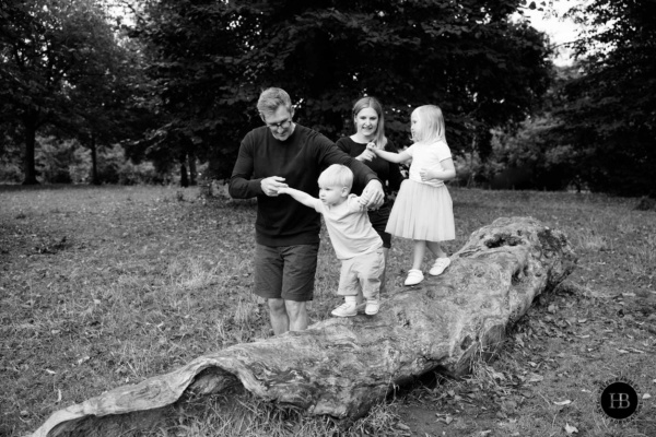 parents-help-children-balance-on-log