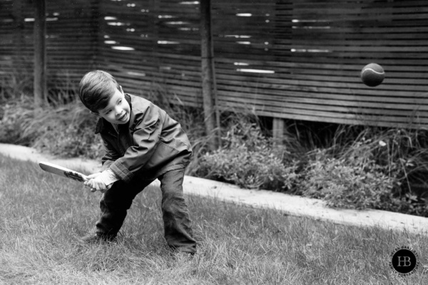 boy-plays-cricket-in-garden-on-rainy-family-photo-shoot