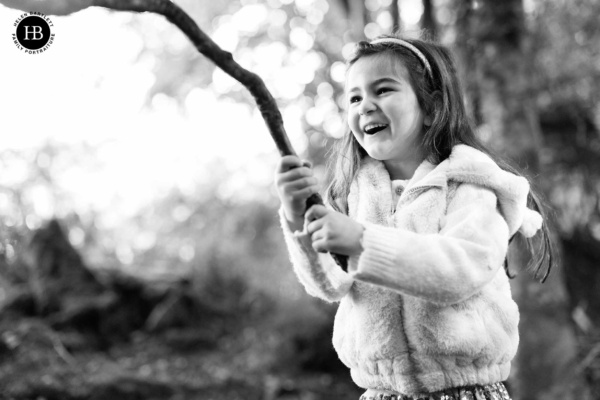 girl-plays-in-woodland-on-family-photo-shoot