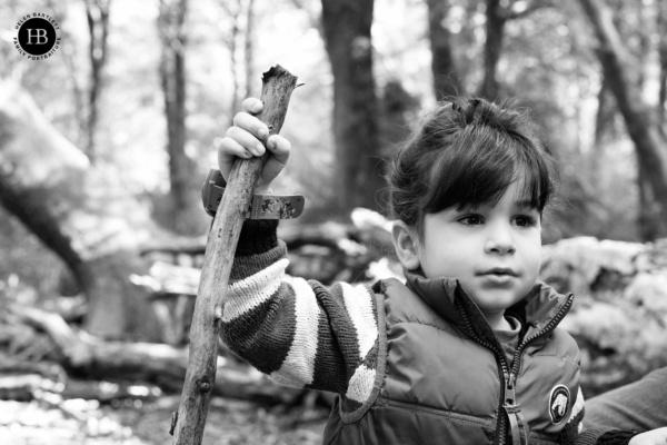 young-boy-marches-through-woods-with-stick