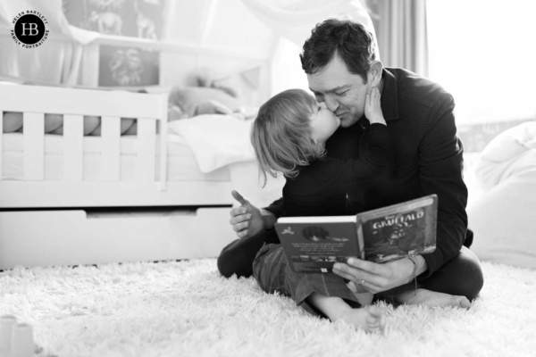 son-kisses-father-while-reading-a-book