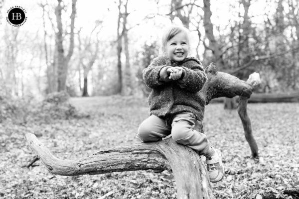 cute-little-girl-sits-on-fallen-tree
