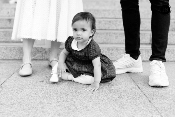 little-girl-sits-by-parents-feet-cute-portrait