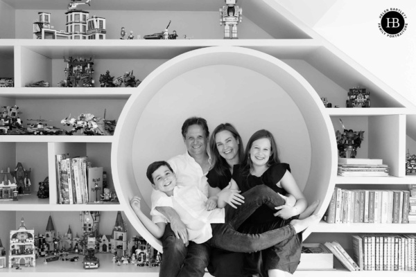 Family of four squeeze into a circular bookcase nook, Lego displays filling the shelves