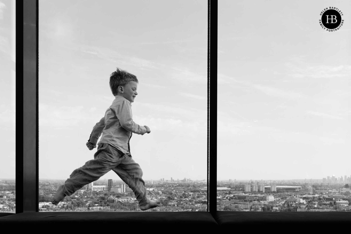 Boy jumping with joy in front of panoramic London view during NW3 photo session