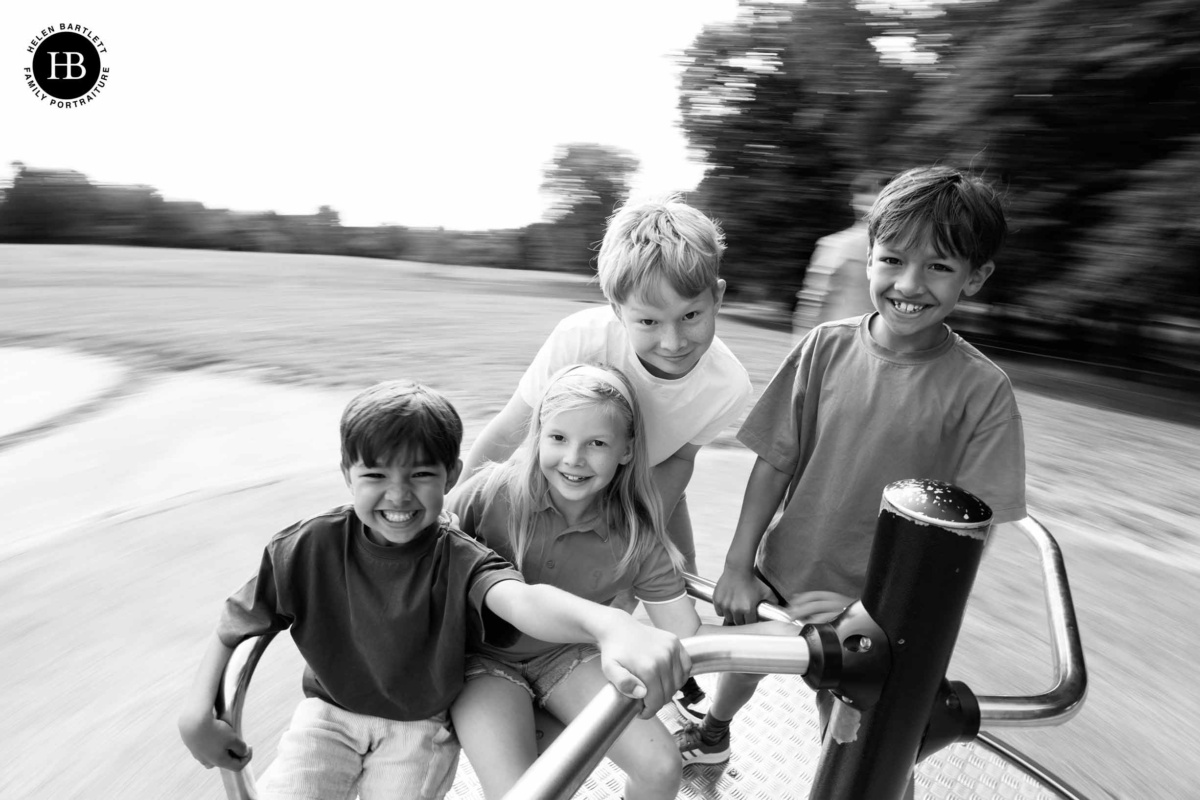 Children laughing while spinning on a roundabout during family photo shoot in South East London