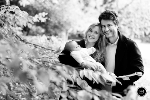 Parents holding their newborn baby during an outdoor photography session in Muswell Hill