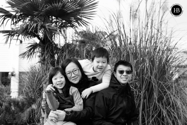 Family sitting together among coastal plants during a photo shoot