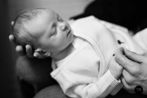 Peaceful newborn resting in a parent’s arms during a relaxed at-home photo session in North London