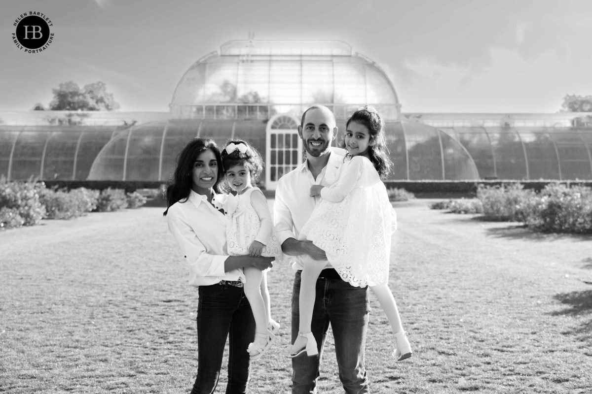 Family standing together in front of the glasshouse at Kew Gardens