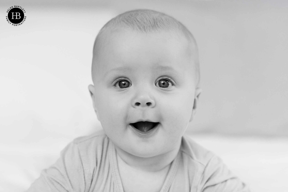 Bright eyed baby looking at camera in a relaxed home baby photography session in Finsbury Park
