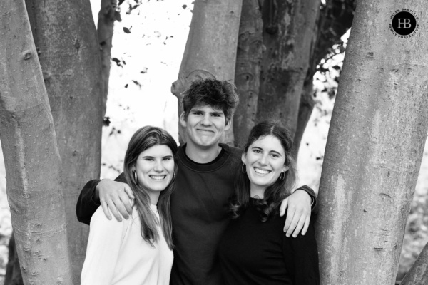 Relaxed portrait of teenage siblings standing together by trees