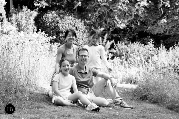 Family portrait sitting together beside a tall wildflower border