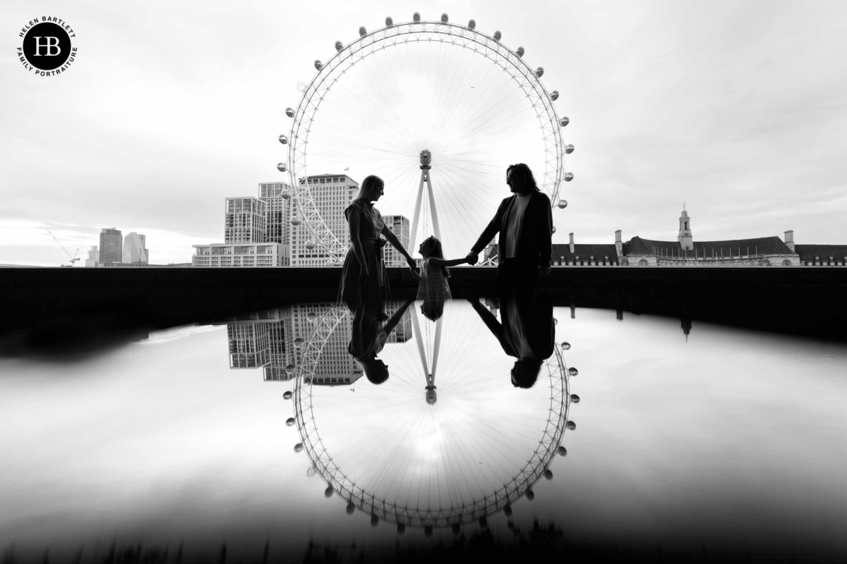 family silhouetted with the London eye and a reflection of the same by photographer Helen Bartlett