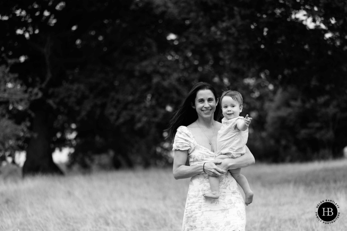Mother carrying her young son as they walk across Brockwell Park
