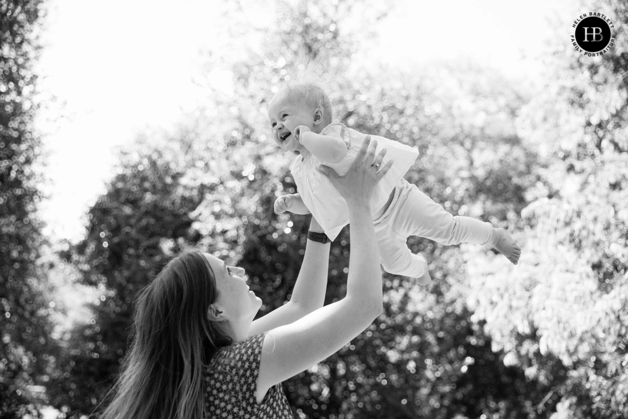 joyful baby photography islington n1 mother throwing laughing baby in the air