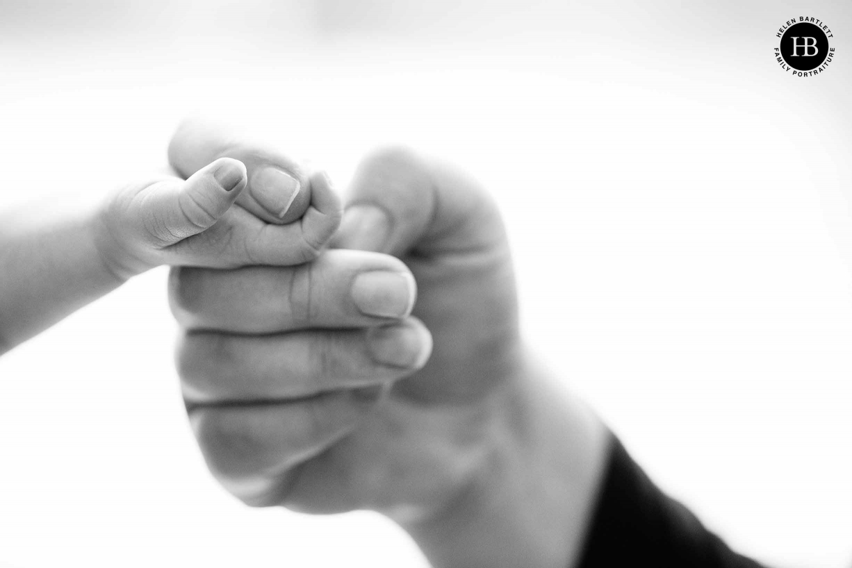 newborn baby holds mum's finger, black and white professional photo