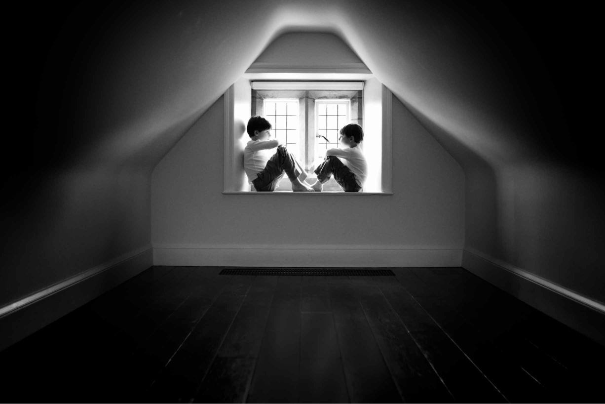 boys sit in a window in beautiful architectural nook on professional photo shoot