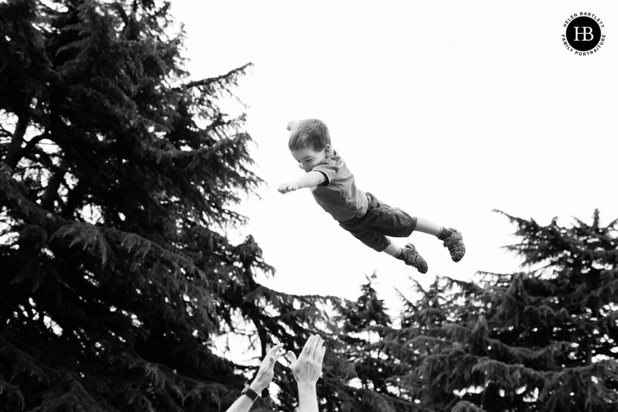 child laughs in delight as thrown in the air on a photo shoot in Islington N1