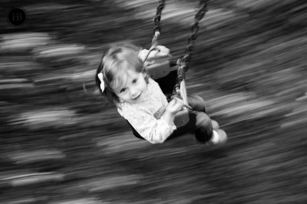 girl on a swing shot from above using panning technique during a family photography session in Islington N1