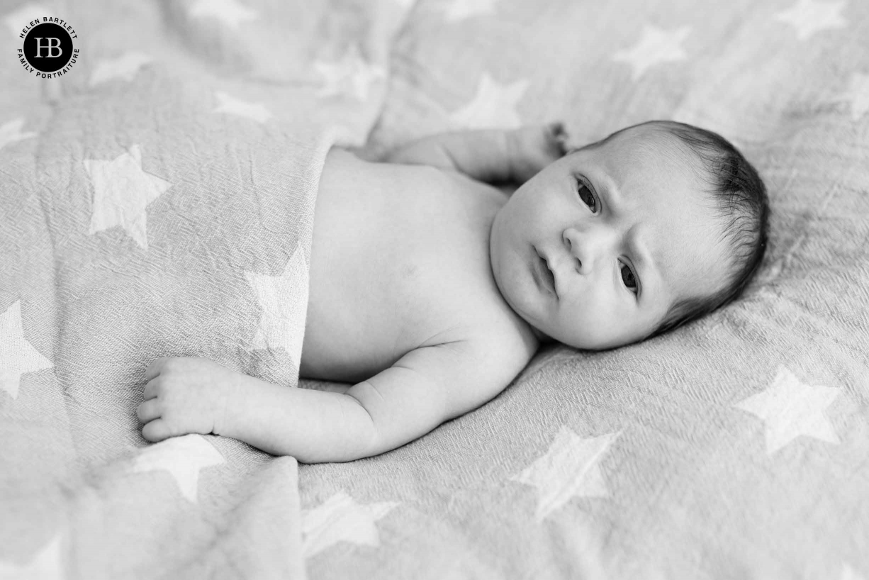 newborn boy looks at camera with quizzical expression