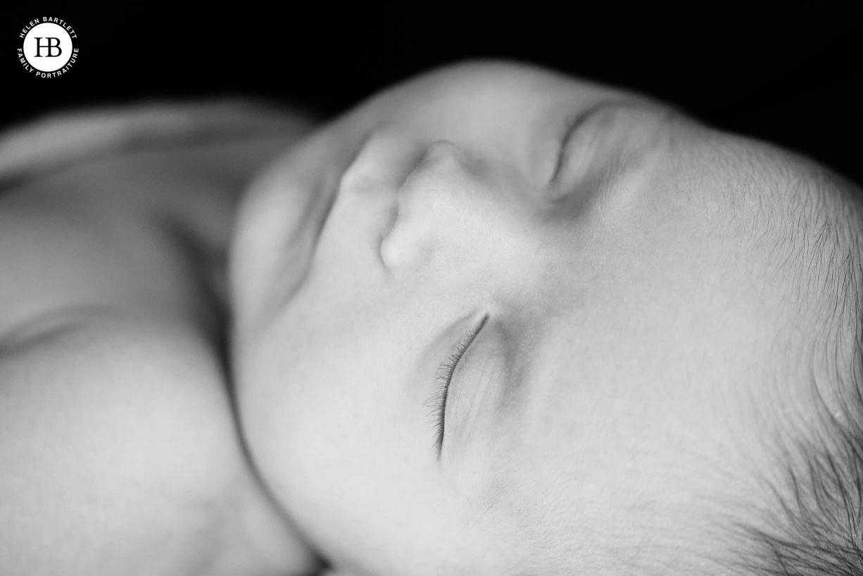 close up shot of sleeping newborn face, dark background