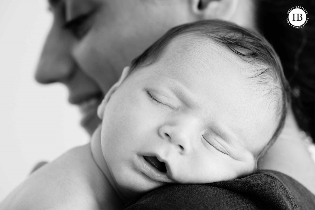 close up of baby sleeping on mums shoulder