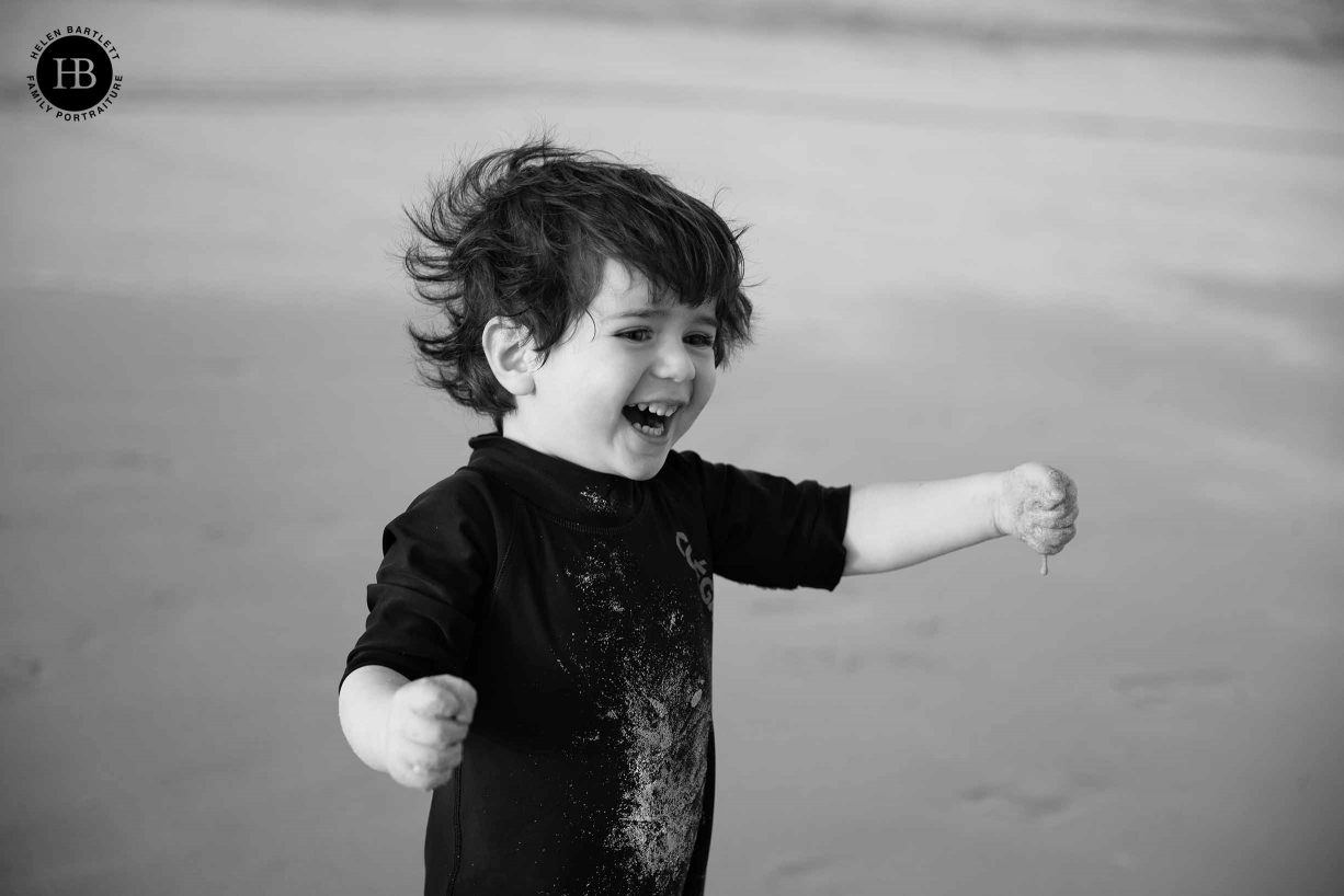 small boy plays in the sand on the beach