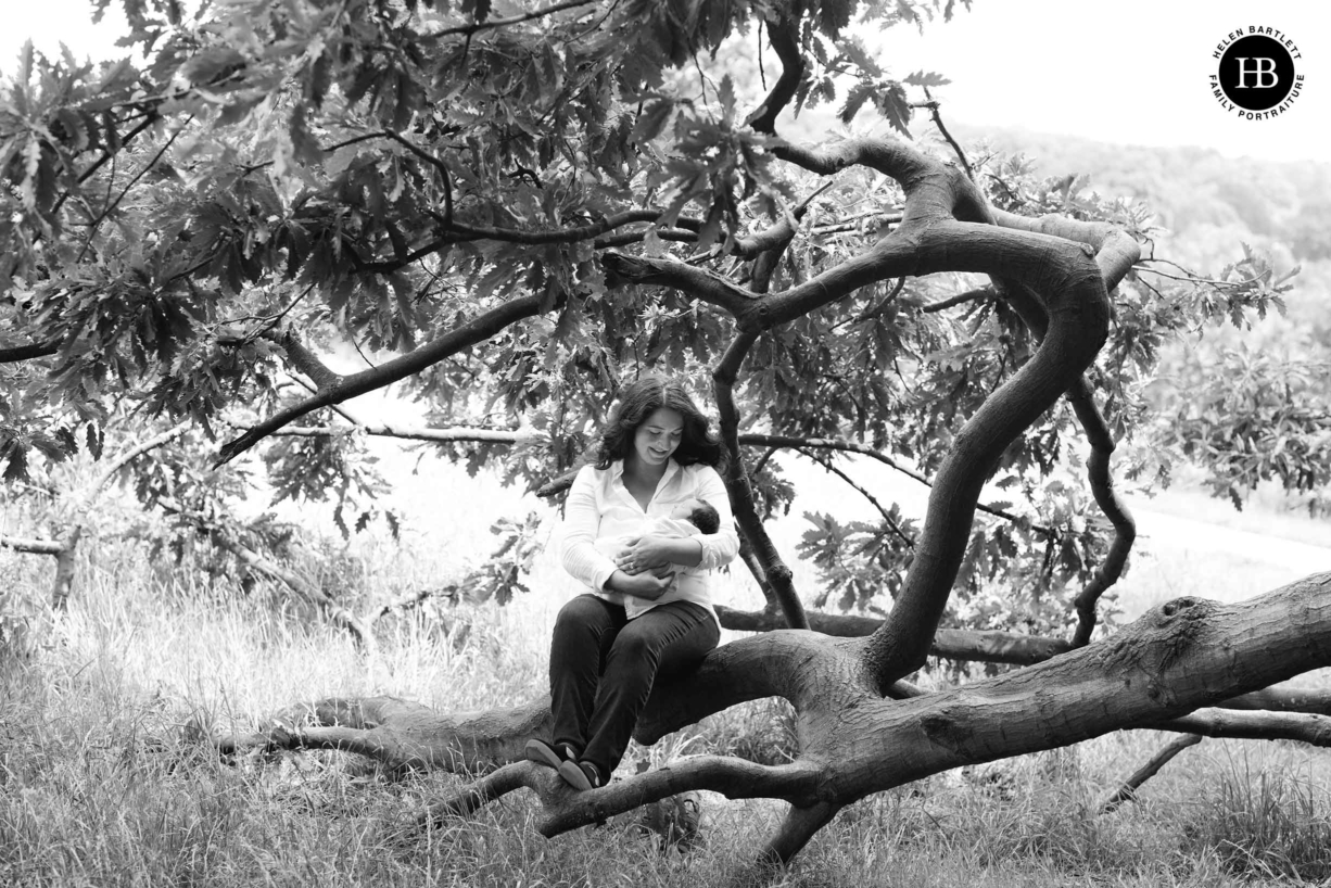 Mum Sits with newborn baby on fallen tree on Hampstead Heath NW7 and NW5