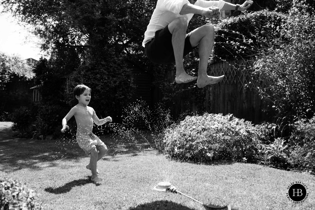 A child plays in a black and white family photo in a Blackheath garden