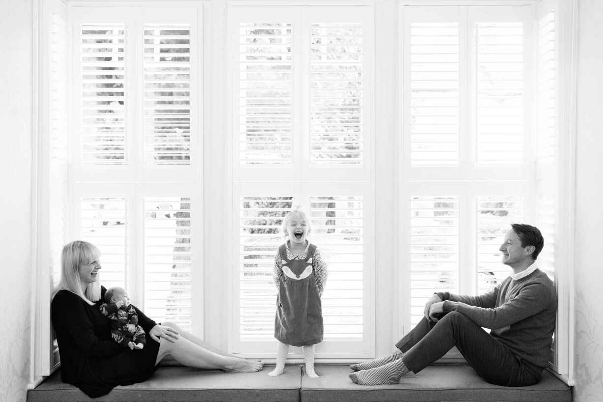 A vista of sunlit windows is the background for this Chiswick family portrait.