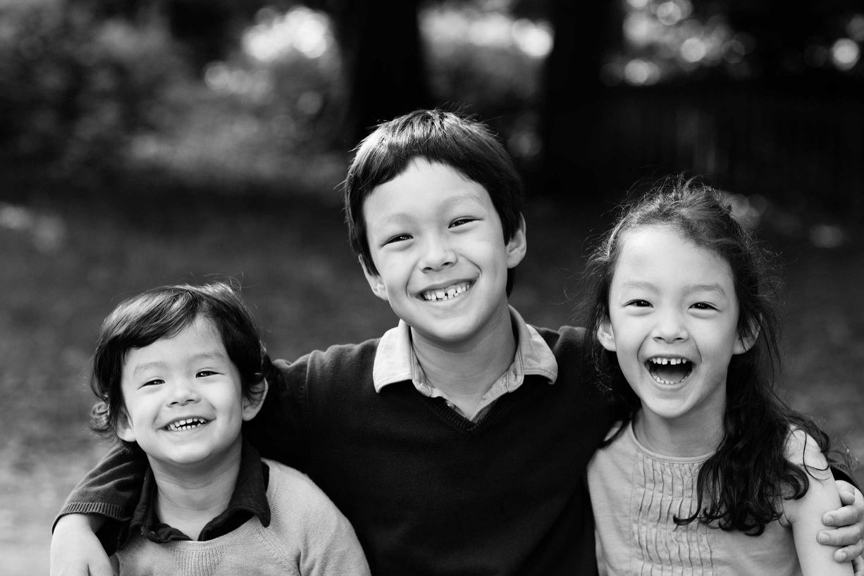 Siblings giggle during their family photography in Knightsbridge