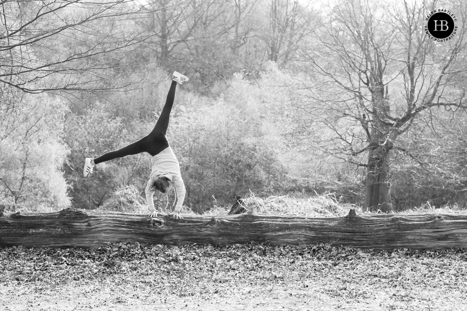 A girl cartwheels across a garden in this black and white photo taken during a family photoshoot.